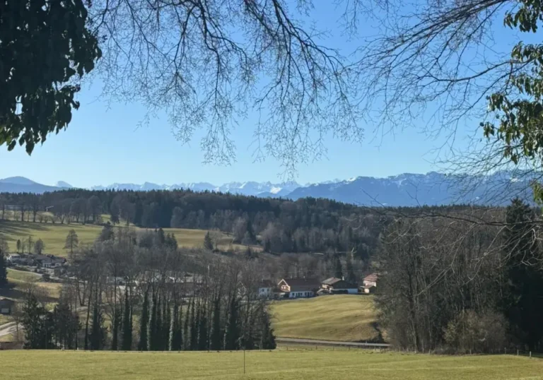 Blick über Wiesen und Wälder bei Dietramszell auf die Alpen