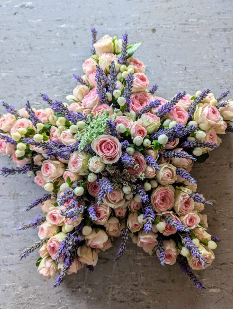 Sternförmiges Trauergesteck aus rosa Rosen und Lavendel