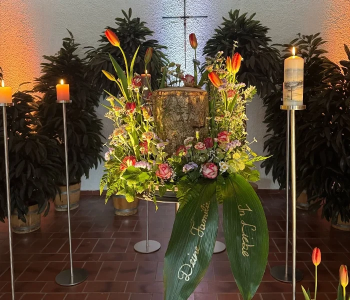 Holzstammurne mit Dekoration und Beleuchtung in der Aussegnungshalle in Starnberg