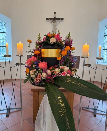 Schwarze Urne mit sommerlicher Trauerfloristik Schwarze Urne mit sommerlicher Trauerfloristik